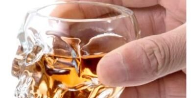 Crystal skull shot glass filled with whiskey or liquor for home bar decor